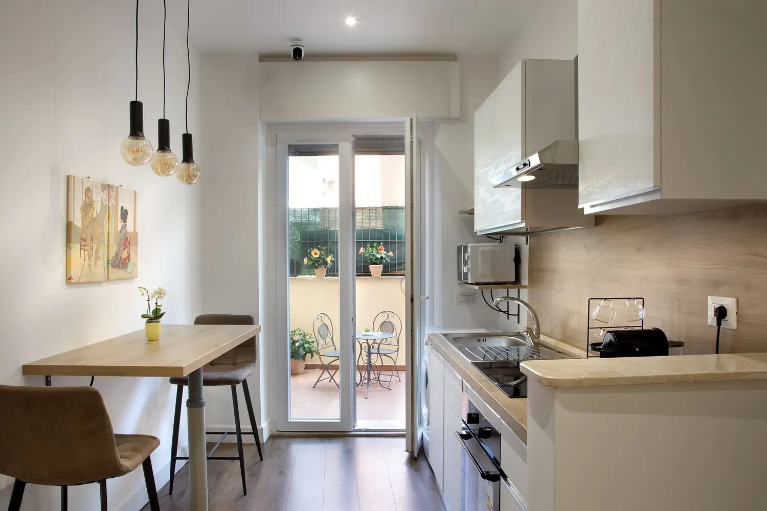 La cucina comune con tavolo alto e porta sul terrazzo