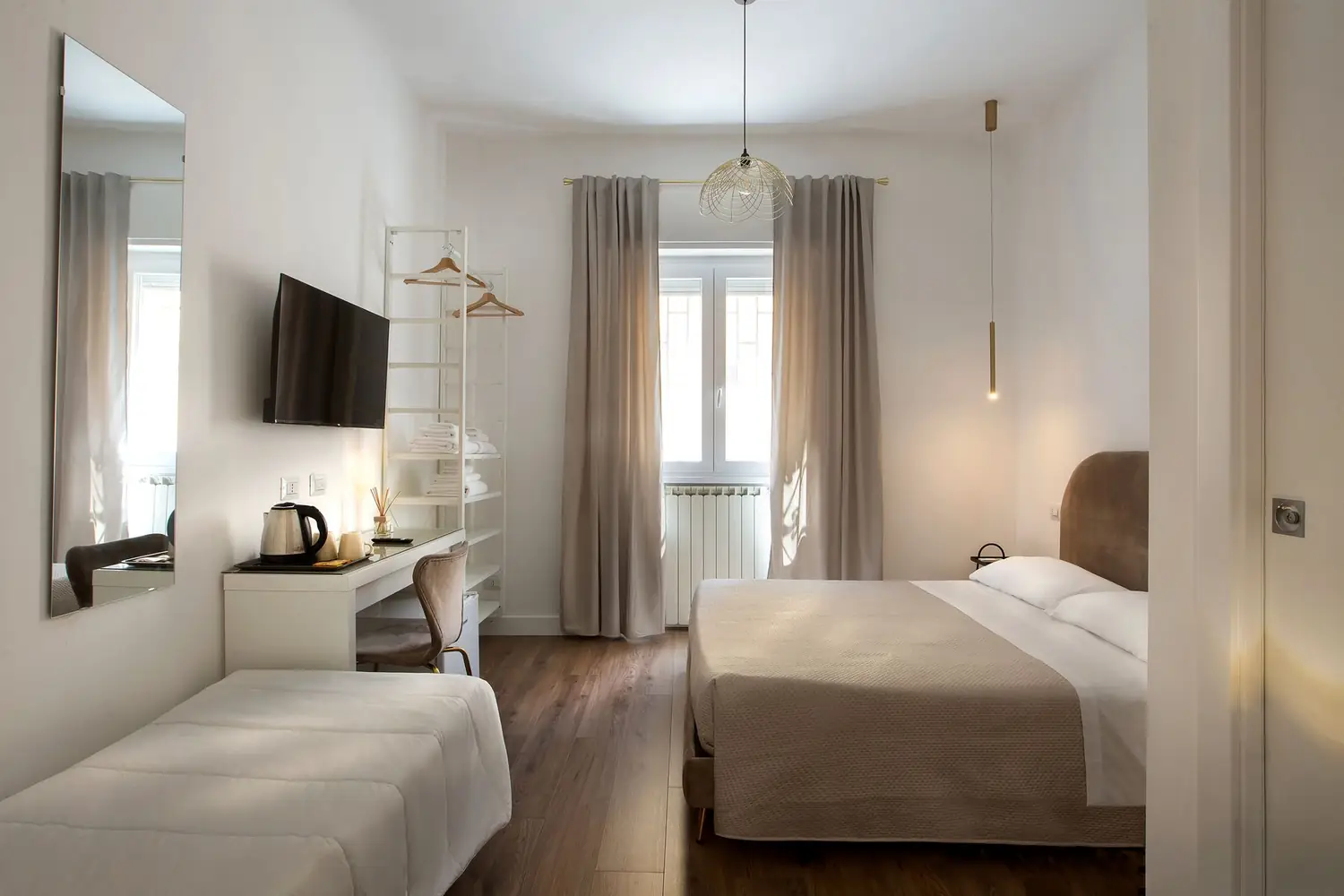 Camera Tosca: letto matrimoniale, letto singolo e zona lavoro, nei toni della terra di Roma